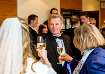 Gaste stoßen bei einer Hochzeitsfeier im Marina Resort mit Sekt an. Hochzeitsfotografie in Bernried.