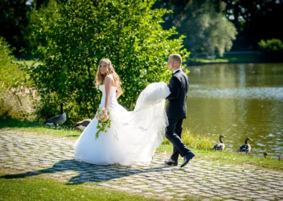 Brautpaar-Shooting am See in Schloss Blutenburg, Oberbayern. Braut mit Blumenstrauss, Bräutigam trägt Kleid.