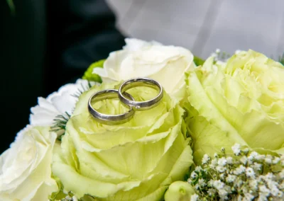 Zwei Eheringe auf cremefarbenen Rosen bei einer Hochzeit nahe München, festgehalten in einer Hochzeitsreportage.