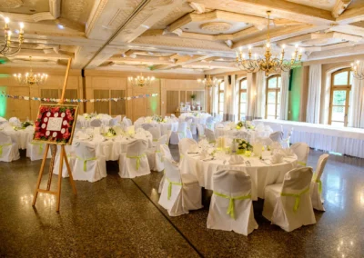 Hochzeitsdekoration im Saal mit gedeckten Tischen und Kronleuchtern, Hochzeit nahe Feldkirchen.