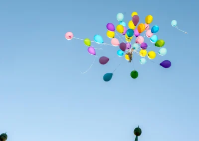 Bunte Luftballons steigen in den Himmel bei einer Hochzeit in Schloss Blutenburg, Obermenzing. Hochzeitsfoto Stimmung.