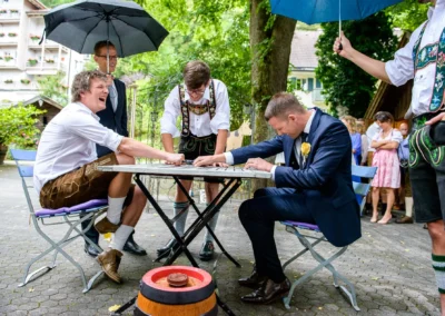 Hochzeitsfeier in Bad Toelz mit spielenden Maennern in Tracht und Anzug im Freien, bayerische Tradition.