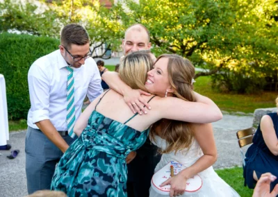 Braut umarmt Gaeste bei einer Hochzeit in Oberbayern im Freien, festgehalten von Hochzeitsfotograf München.