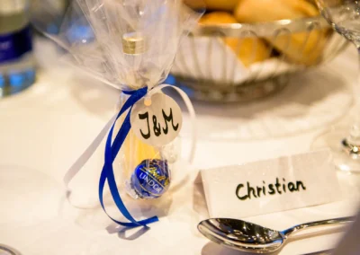 Kleines Gastgeschenk mit blauer Schleife und Namensschild bei Hochzeitsfeier in Bernried.