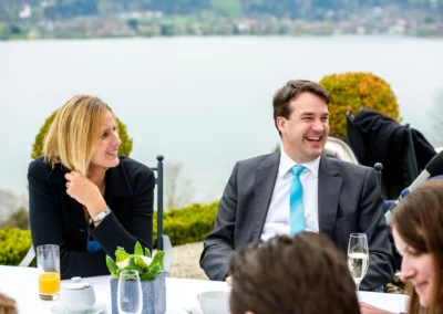 Gaste lachen bei Hochzeitsfeier im Tegernsee Hotel. Perfekt für Hochzeitsreportagen in Oberbayern.