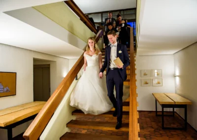 Brautpaar geht Hand in Hand eine Treppe bei Hochzeitsfeier in Bernried hinunter. Hochzeitsreportage in stilvoller Umgebung.