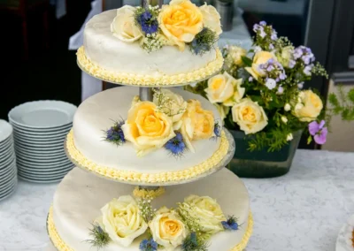 Hochzeitstorte mit gelben Rosen bei Trauung am Chiemsee, ideal fuer Hochzeitsreportage in Oberbayern.