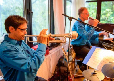 Musiker spielt Trompete bei Hochzeitsfeier im Hotel Kolbergarten, Bad Toelz. Hochzeitsfoto zeigt musikalische Einlage.