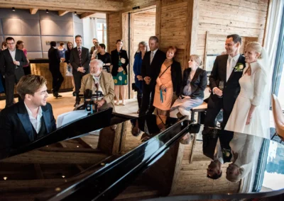 Brautpaar beim Empfang im Tegernsee Hotel mit Gästen und Pianist, Hochzeitsfeier, festliche Stimmung, Trauung.