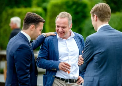 Männer lachen bei einer Hochzeit im Seehotel Malerwinkel. Hochzeitsfotografie in entspannter Atmosphaere.