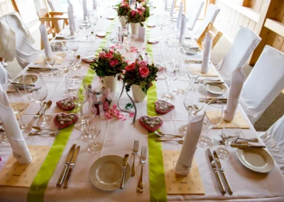 Elegante Tischdekoration mit Blumenarrangement bei Hochzeit am Tegernsee, festgehalten von einem Hochzeitsfotografen.