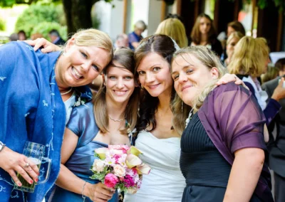 Gäste bei einer Hochzeitsfeier in Bad Wiessee, lachend und posierend, Braut mit Blumenstrauss, Hochzeitsreportage.