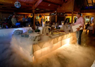 Hochzeitsfoto im Wirtshaus am Rosengarten, festlich gedeckter Tisch mit Dessertbuffet und Nebel durch Trockeneis.