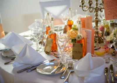 Elegante Hochzeitsdekoration in Schloss Blutenburg, München. Tafel mit Blumen und Glasflaschen bei einer Trauung.