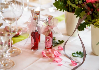 Hochzeitsfoto: Tischdekoration mit kleinen Flaschen und Blumenarrangement bei einer Hochzeit im Seehotel Malerwinkel.