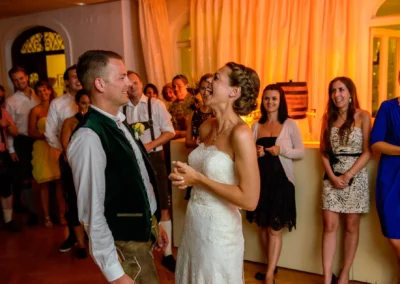Brautpaar lacht während Hochzeitsfeier im Hotel Kolbergarten in Bad Tölz, festgehalten von Hochzeitsfotograf.