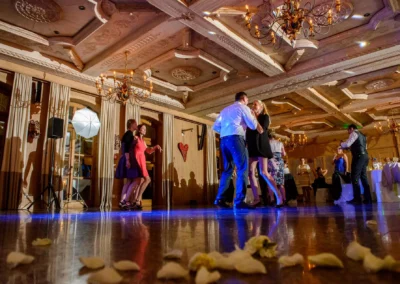 Gaste tanzen bei einer Hochzeitsfeier nahe Feldkirchen im prunkvoll beleuchteten Saal mit Kronleuchtern im Hotel Bauer.