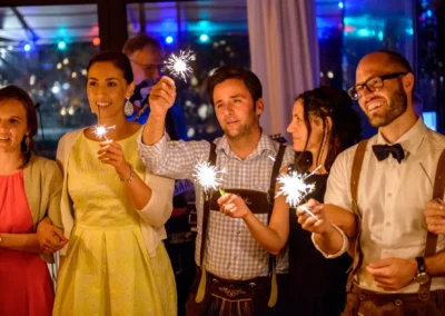 Gruppe von Gaesten bei Hochzeitsfeier im Hotel Kolbergarten, Bad Toelz, mit Wunderkerzen, fröhliche Stimmung.