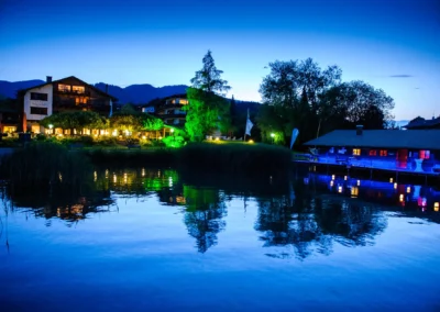 Abendliche Hochzeitsfeier am Tegernsee mit beleuchtetem Terrassenhof, stimmungsvoll in Bad Wiessee fotografiert von Hochzeitsfotograf Tegernsee.