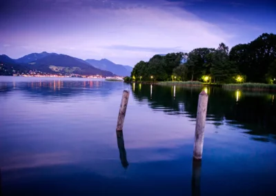 Abendstimmung am Tegernsee bei einer Hochzeitsfeier, beleuchtete Kulisse mit Wasser und Wald. Foto von Hochzeitsfotograf Bad Wiessee