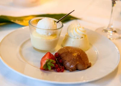 Hochzeitsdessert auf Teller bei Feier in Bad Wiessee, Schoko- und Vanillepudding mit Beeren und Sahne.