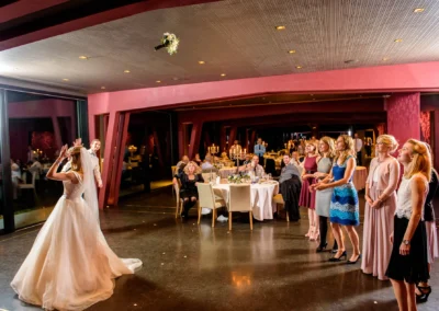 Braut wirft Brautstrauss bei einer Hochzeit im Marina Resort in Bayern, Gaeste warten darauf, ihn zu fangen.