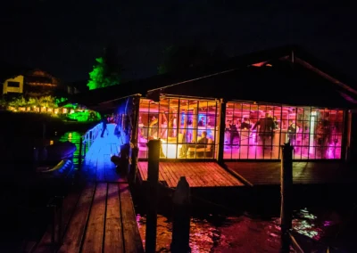 Hochzeitsfeier am Tegernsee mit bunten Lichtern bei Nacht, ausgelassene Stimmung. Hochzeitsreportage am Tegernsee in Bayern.
