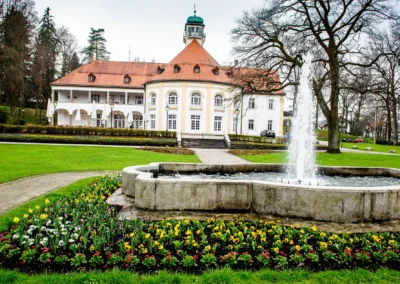 Kurhaus Bad Toelz mit blühendem Garten und Brunnen, ideal für Hochzeitsfotografie in Oberbayern.