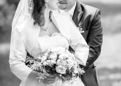 Brautpaar-Shooting in Oberbayern, Hochzeitsportrait mit Brautstrauss und Lächeln, festgehalten vom Hochzeitsfotograf.