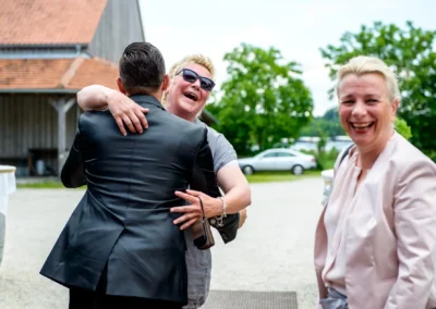 Lachende Gäste bei freier Trauung im Schloss Sulzemoos, festgehalten von einem Hochzeitsfotografen.