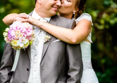Brautpaar-Shooting bei Hochzeit im Gasthof Stangl, Brautpaar laechelt im Garten, aufgenommen von Hochzeitsfotograf.