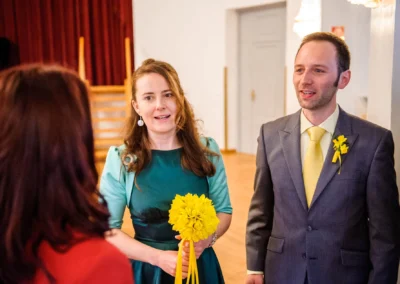 Brautpaar bei standesamtlicher Trauung in Bad Tölz, Frau mit gelbem Blumenstrauss, Hochzeitsfotografie.