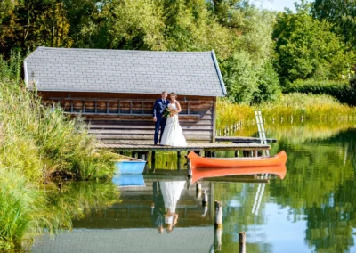 Brautpaarshooting am Steg nahe Wesslinger See, umgeben von Booten und Natur, betont durch Hochzeitsfotografie.