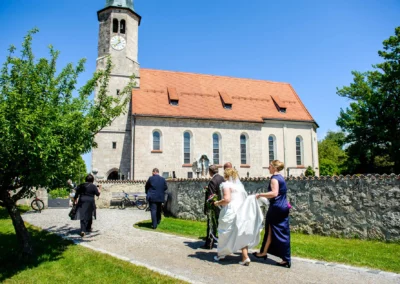 Brautpaar auf dem Weg zur kirchlichen Trauung in der Frauenkirche Osterwarngau. Hochzeitsreportage in Oberbayern.