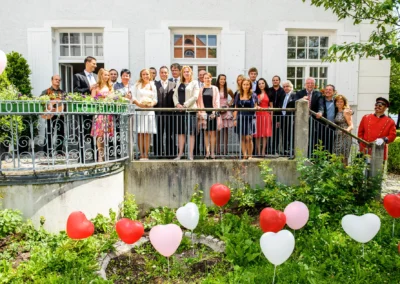 Hochzeitsgesellschaft bei standesamtlicher Trauung in Haar bei Muenchen, Gruppenfoto mit herzfoermigen Luftballons.