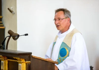 Priester bei kirchlicher Trauung in St. Benedikt Gelting. Hochzeitsfotograf dokumentiert Zeremonie.