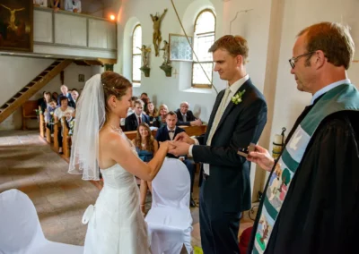 Brautpaar tauscht Ringe bei kirchlicher Trauung in Glonn, festgehalten von Hochzeitsfotograf für Hochzeitsreportage.