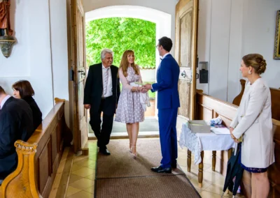 Gaste betreten die Kirche in Moosach bei Grafing zur kirchlichen Trauung, festgehalten in einer Hochzeitsreportage.