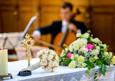 Blumendekoration und Kerze bei kirchlicher Trauung in St. Benedikt Gelting, Hochzeitsfotografie.