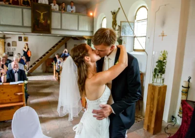 Brautpaar beim Kuss während der kirchlichen Trauung in Gut Georgenberg. Hochzeitsfotografie in Oberbayern.
