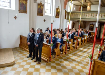 Gäste in der Kirche Mariä Heimsuchung bei einer Hochzeit in Oberbayern, festliche Hochzeitsreportage.