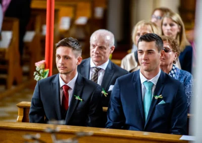 Zwei Maenner in Anzug bei kirchlicher Hochzeit in Grosshartpenning. Hochzeitsreportage von Hochzeitsfotograf.