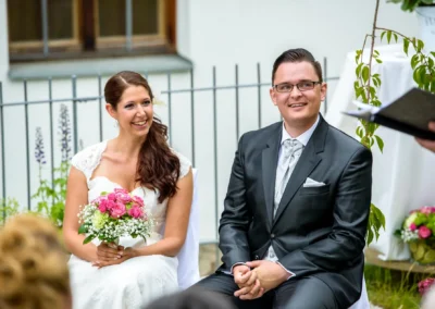 Hochzeitspaar bei freier Trauung auf Gut Schloss Sulzemoos, lachend und voller Freude, Hochzeitsfotografie.