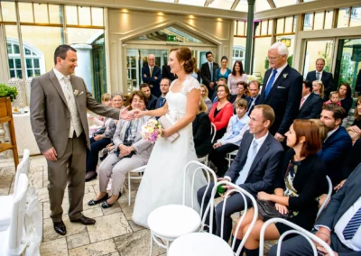 Braut und Braeutigam bei freier Trauung im Gasthof Stangl, umgeben von Gaesten, aufgenommen von einem Hochzeitsfotograf.