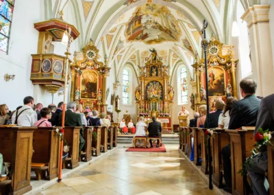 Kirchliche Trauung in der Frauenkirche Osterwarngau, Brautpaar kniet am Altar bei der Hochzeitsfoto-Aufnahme.