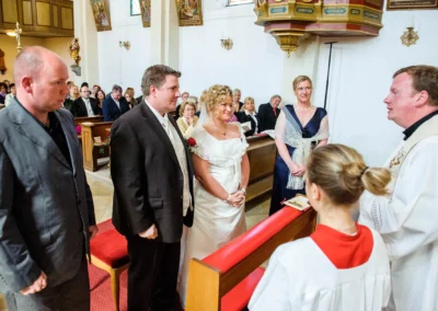 Brautpaar waehrend kirchlicher Trauung in Kirche in Bayern, aufgenommen von Hochzeitsfotograf bei Hochzeitsreportage.