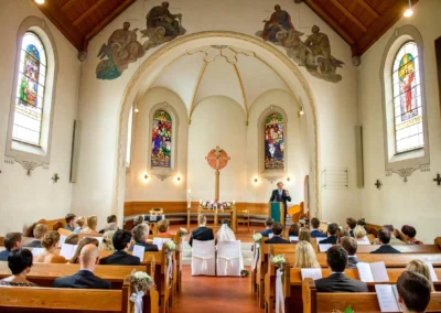 Kirchliche Trauung in der neuapostolischen Kirche, Oberbayern. Hochzeitsreportage mit Gästen und Prediger.