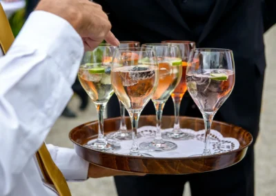 Glaeser mit Cocktails auf Tablett bei Hochzeitsfeier auf Gut Georgenberg. Aufnahme von Hochzeitsfotograf in Oberbayern.