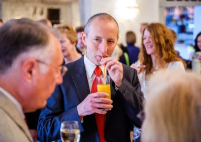 Gast bei Hochzeit im Kurhaus Bad Toelz mit Orangensaft, gesellige Atmosphaere, Teil der Hochzeitsreportage.