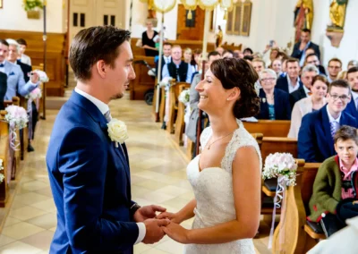 Brautpaar bei der kirchlichen Trauung in der Dorfkirche Moosach, liebevoller Moment der Hochzeitsfotografie.
